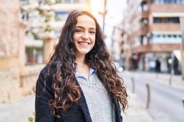 Sokakta kendine gülen genç İspanyol kadın.