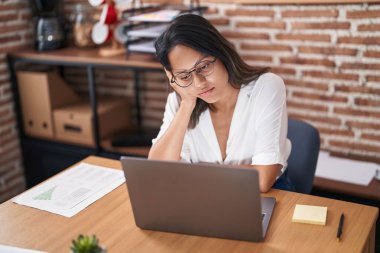 Young hispanic woman business worker stressed using laptop at office