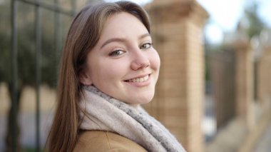 Sokakta kendine güvenen genç sarışın kadın gülümsüyor