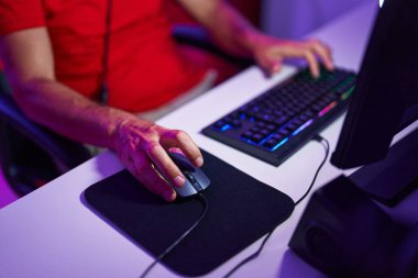 Middle age man using computer keyboard and mouse at gaming room