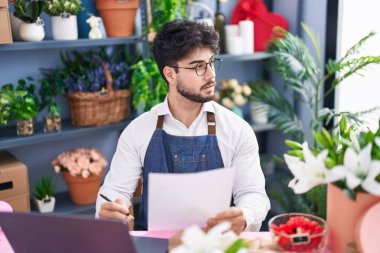 Çiçekçide doküman okuyan İspanyol bir çiçekçi.