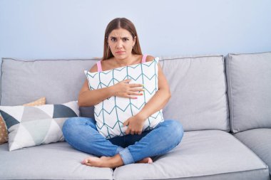 Kanepede oturan genç sarışın kadın şüpheci ve gergin, sorun yüzünden surat asıyor. negatif kişi. 