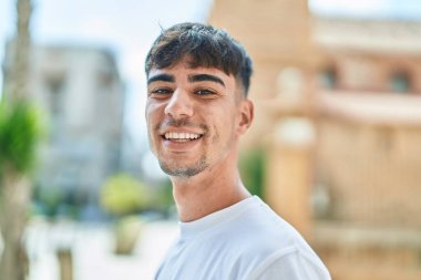 Sokakta kendinden emin gülümseyen İspanyol genç adam.