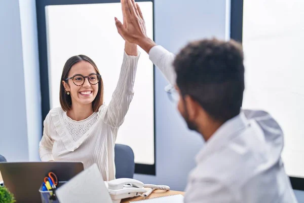 stock image Man and woman business workers high five with hands raised up at office