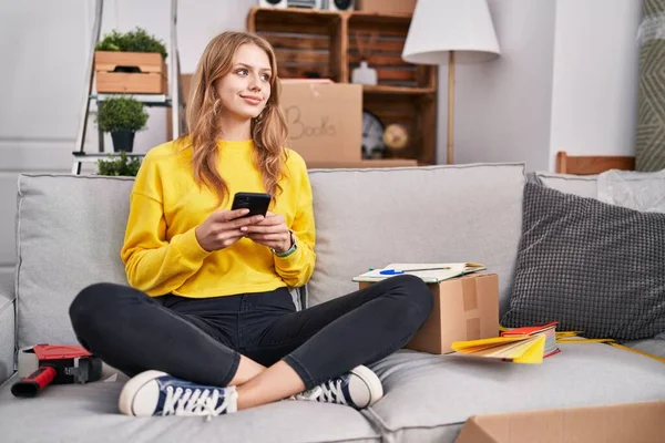 Young Blonde Woman Using Smartphone Sitting Sofa New Home — Stockfoto