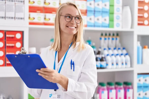 Young Blonde Woman Pharmacist Writing Document Pharmacy —  Fotos de Stock