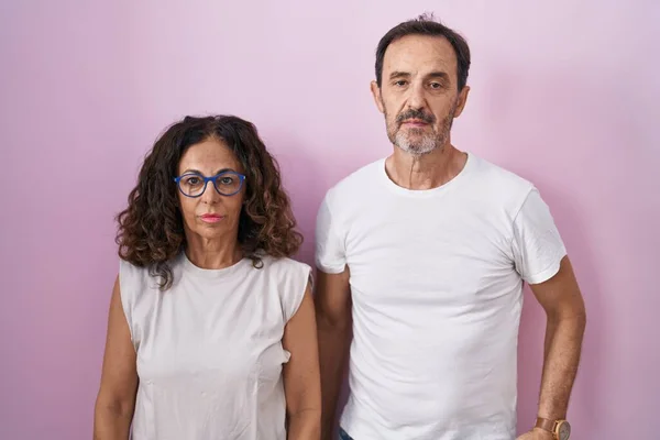 Middelbare Leeftijd Hispanic Paar Samen Roze Achtergrond Ontspannen Met Ernstige — Stockfoto