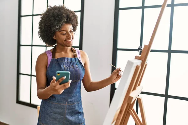 在艺术工作室用智能手机绘图 年轻的非洲裔美国女人充满自信地微笑着 — 图库照片