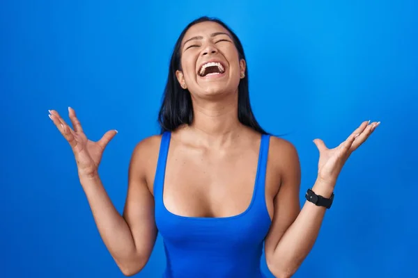Hispanic Woman Standing Blue Background Celebrating Mad Crazy Success Arms — ストック写真