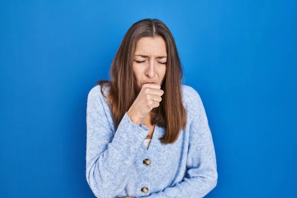 站在蓝色背景上的年轻妇女感觉不适 咳嗽是感冒或支气管炎的症状 保健概念 — 图库照片