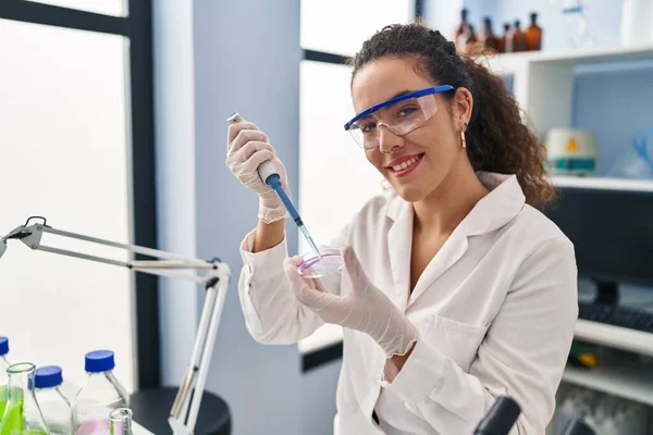 若い美しいヒスパニック系女性科学者は 実験室でサンプルに液体を注ぐ — ストック写真