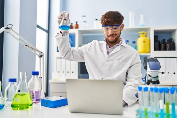 Young Arab Man Scientist Using Laptop Measuring Liquid Laboratory — Stok fotoğraf