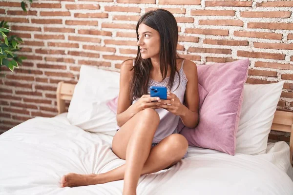 Νέα Όμορφη Ισπανόφωνη Γυναίκα Χρησιμοποιώντας Smartphone Κάθεται Στο Κρεβάτι Στο — Φωτογραφία Αρχείου