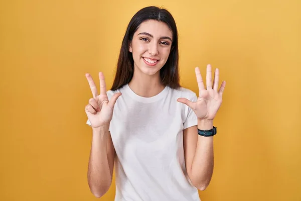 Mladá Krásná Žena Stojící Nad Žlutým Pozadím Ukazující Ukazující Prsty — Stock fotografie
