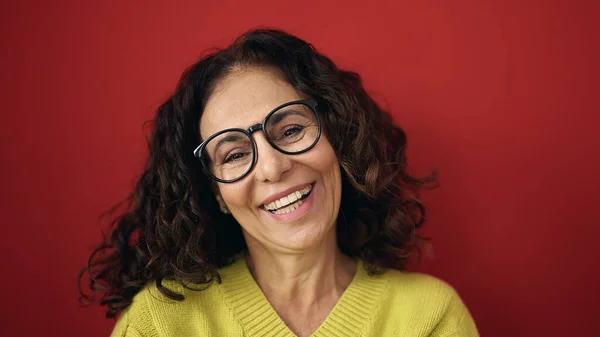 Middelbare Leeftijd Spaanse Vrouw Glimlachend Zelfverzekerd Staande Geïsoleerde Rode Achtergrond — Stockfoto