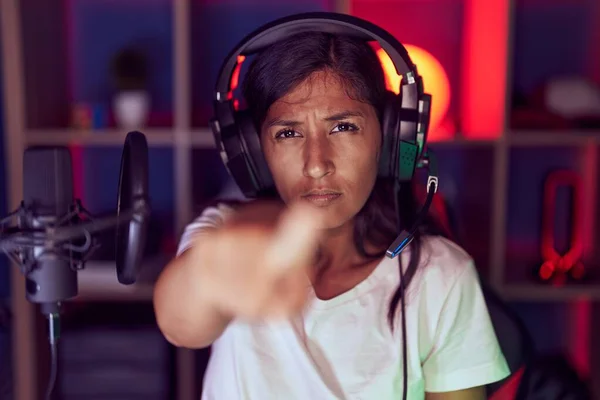 Young Hispanic Woman Playing Video Games Wearing Headphones Pointing Finger —  Fotos de Stock
