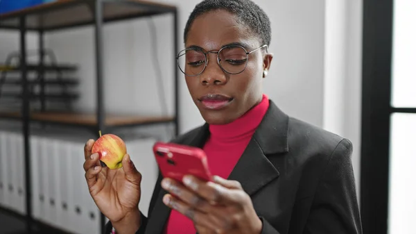 African American Woman Business Worker Using Smartphone Eating Apple Office — Stock Photo, Image