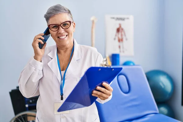 Middle Age Woman Physiotherapist Talking Smartphone Rehab Clinic — Stock Photo, Image