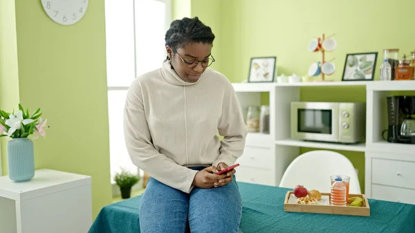 Afro Amerikalı Kadın Yemek Odasında Akıllı Telefon Kullanıyor — Stok fotoğraf
