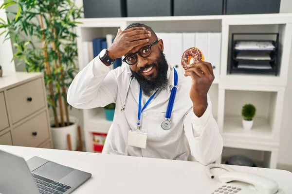 도넛을 영양학 클리닉에서 일하고 아프리카 미국인 남자가 머리에 스트레스와 좌절을 — 스톡 사진