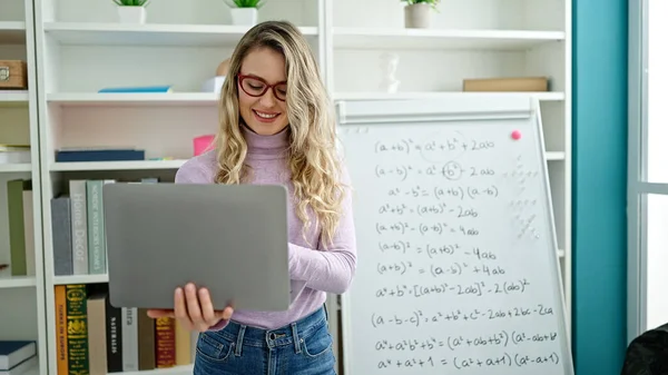 Young Blonde Woman Teacher Teaching Maths Lesson Holding Laptop Classroom — Stock Photo, Image
