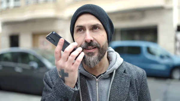 年轻的秃头男子在街上用智能手机发送语音讯息 — 图库照片
