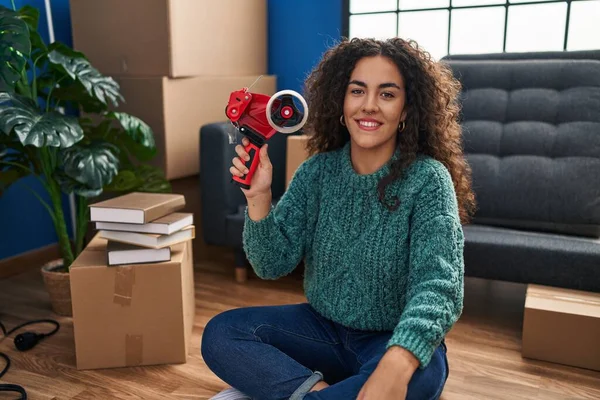 Young Beautiful Hispanic Woman Smiling Confident Holding Package Tape Machine — Stockfoto