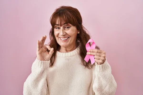 中世のヒスパニック女性保持ピンク癌リボン持っていますOk Signとともに指 笑顔優しいジェスチャー優れたシンボル — ストック写真