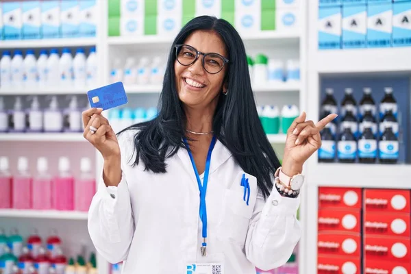 Mujer Hispana Madura Trabajando Farmacia Sosteniendo Tarjeta Crédito Sonriendo Feliz — Foto de Stock
