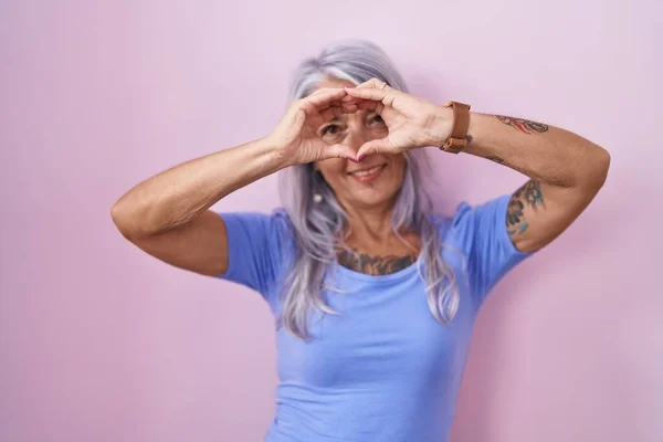 Middle Age Woman Tattoos Standing Pink Background Doing Heart Shape — Stock Photo, Image