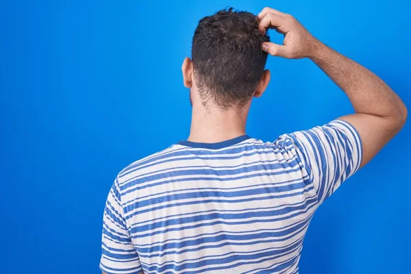 Genç Spanyol Adam Mavi Arka Planda Dikiliyor Elleri Kafasında Şüpheyi — Stok fotoğraf