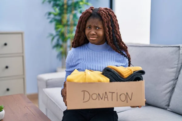 慈善団体のために寄付箱を持っているアフリカの女性は混乱した表現 疑わしい概念 — ストック写真