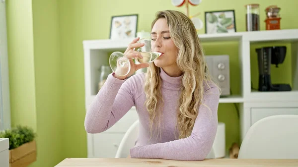 Junge Blonde Frau Trinkt Glas Wein Auf Tisch Esszimmer — Stockfoto