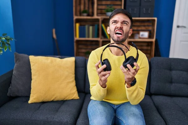 Hispanischer Mann Mit Kaputten Kopfhörern Wütend Und Wütend Schreiend Frustriert — Stockfoto