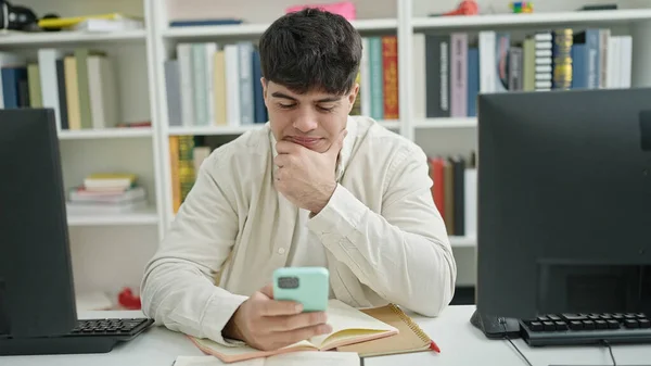 Young Hispanic Man Student Using Smartphone Sitting Table Library University — стоковое фото