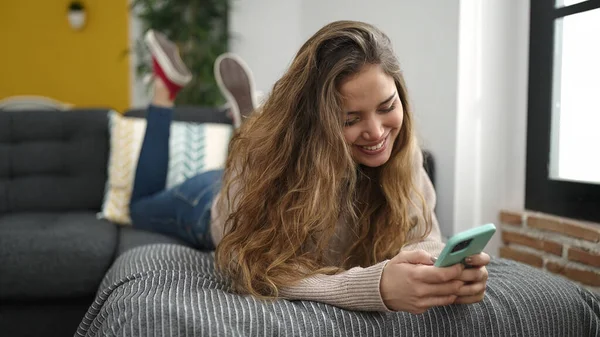 Νεαρή Όμορφη Ισπανόφωνη Γυναίκα Που Χρησιμοποιεί Smartphone Ξαπλωμένη Στον Καναπέ — Φωτογραφία Αρχείου