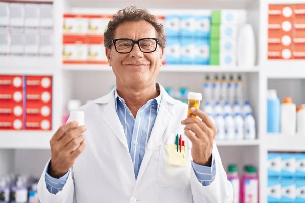 Middle Age Man Pharmacist Smiling Confident Holding Pills Bottles Pharmacy — Stockfoto