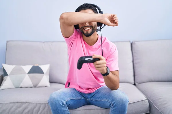 Jovem Hispânico Jogando Videogame Segurando Controlador Sentado Sofá Sorrindo Alegre — Fotografia de Stock