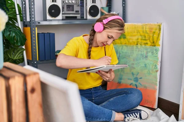 Młoda Blondynka Artystka Słuchająca Muzyki Rysującej Notatniku Pracowni Artystycznej — Zdjęcie stockowe