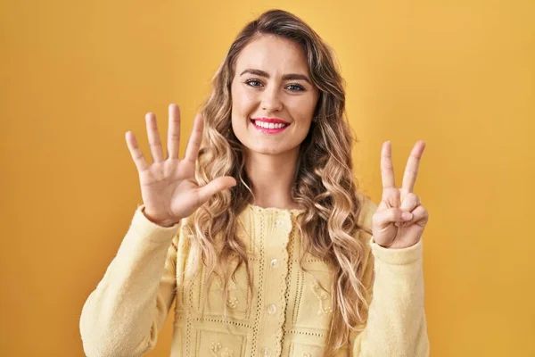 Молода Біла Жінка Стоїть Над Жовтим Тлом Показуючи Вказуючи Пальцями — стокове фото