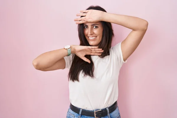 Young Brunette Woman Standing Pink Background Smiling Cheerful Playing Peek — Stockfoto