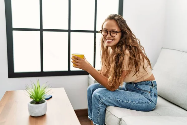 Genç Güzel Spanyol Kadın Evdeki Kanepede Oturup Kahve Içiyor — Stok fotoğraf