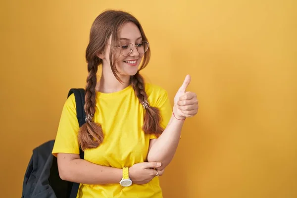 Mladá Běloška Nosí Přes Žluté Pozadí Studentský Batoh Pyšně Usmívá — Stock fotografie
