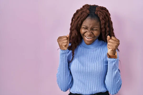 Африканская Женщина Стоящая Розовом Фоне Взволнована Успехом Поднятыми Руками Закрытыми — стоковое фото