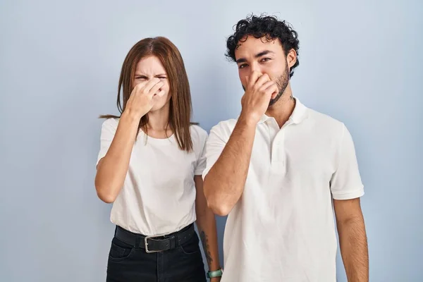 年轻夫妇穿着休闲装站在一起 闻到一股难闻恶心的气味 用手指捂住鼻子屏住呼吸 — 图库照片