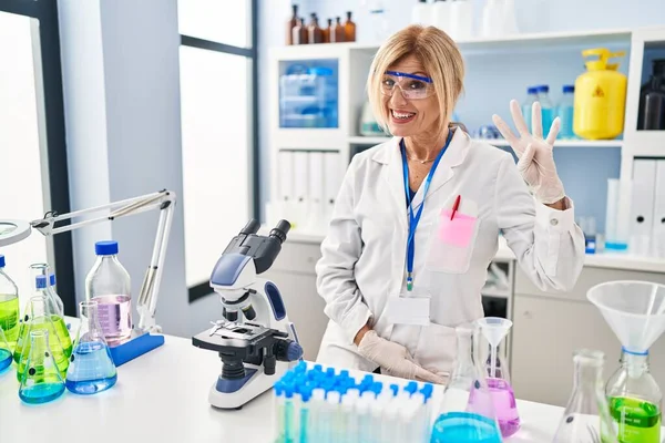 Středního Věku Blondýny Žena Pracující Laboratoři Vědec Ukazuje Ukazuje Prsty — Stock fotografie