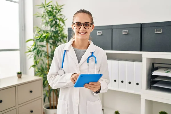 Young Blonde Woman Wearing Doctor Uniform Using Touchpad Working Clinic — Stockfoto