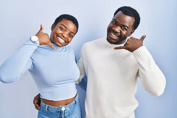 Młoda Afrykańska Para Stojąca Nad Niebieskim Tłem Uśmiechająca Się Wykonująca — Zdjęcie stockowe