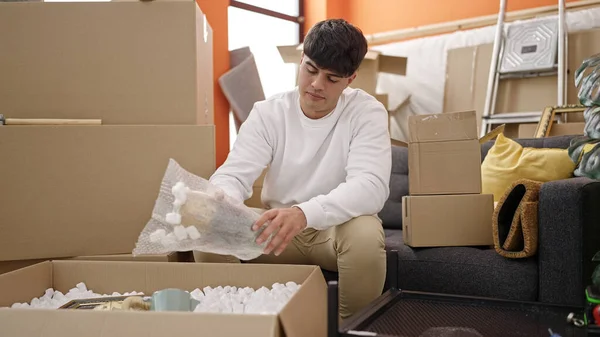 Young Hispanic Man Unpacking Cardboard Box New Home — 스톡 사진
