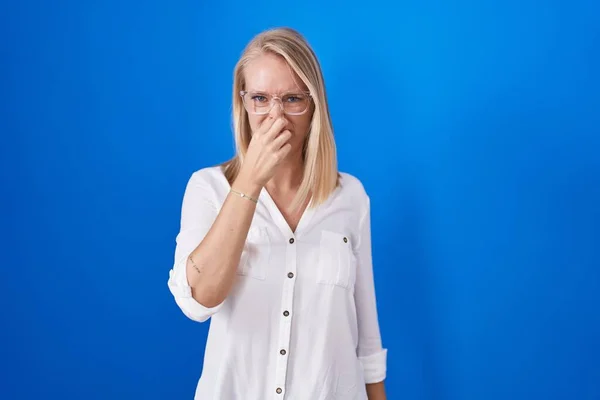 Young Caucasian Woman Standing Blue Background Smelling Something Stinky Disgusting — Stok fotoğraf